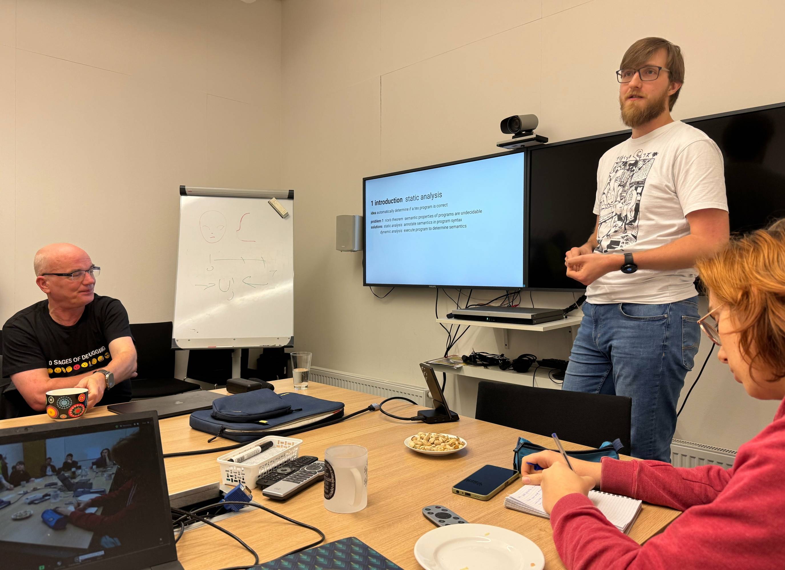 Image: I discuss with Frank and students why the static analysis of
                  expl3 programs is more feasible than the static analysis of
                  TeX programs in general. (Photo by Petr Sojka)